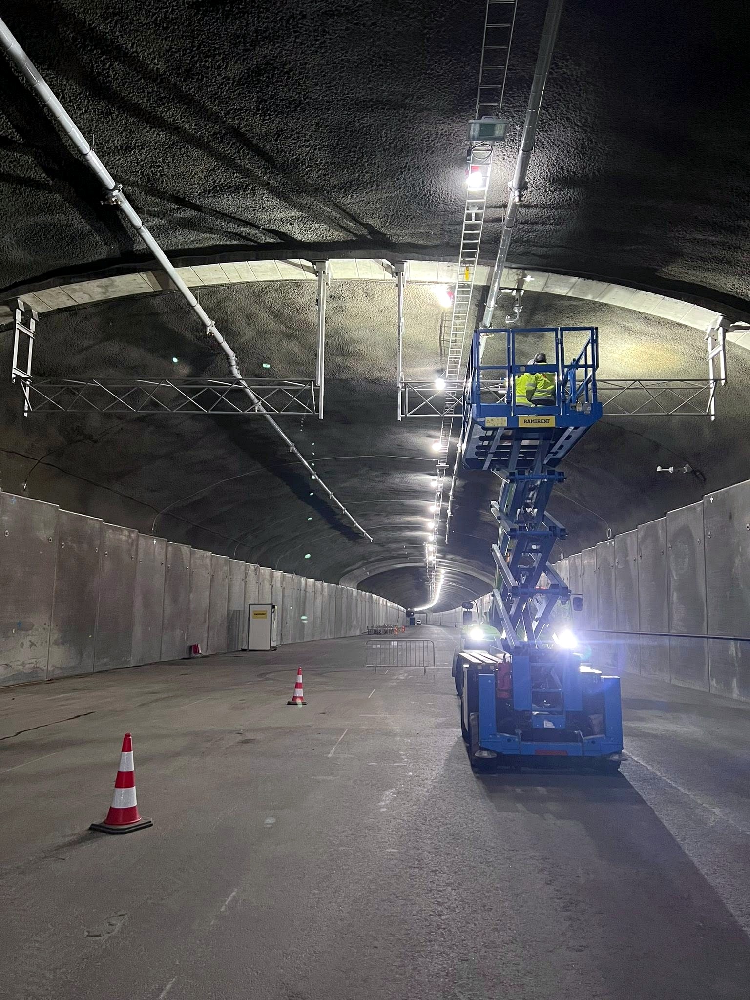Montörer i saxlift monterar teknisk utrustning i tunnel